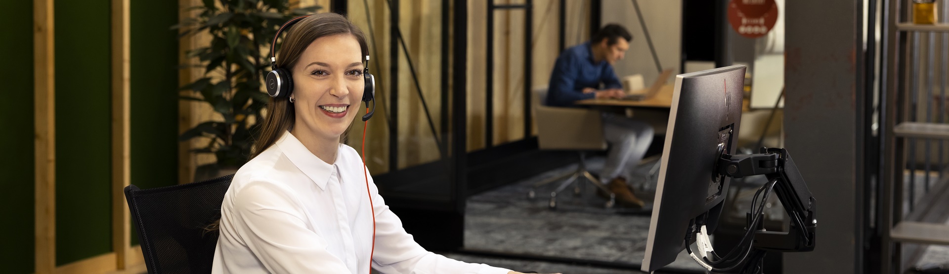 a woman with a headset sitting behind a computer